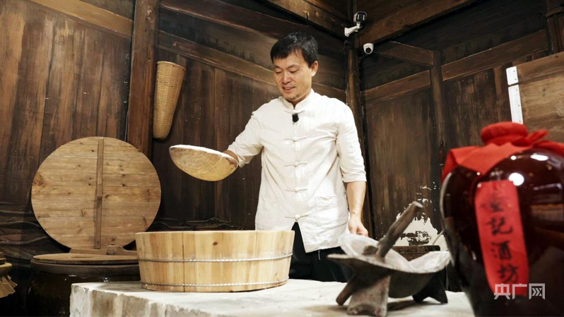 查永红向游客展示酿酒技艺（央广网记者 郇康新 摄）